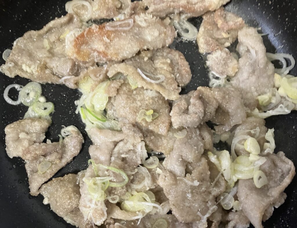 長ネギとにんにくを加えてさらに炒めた豚肉の画像