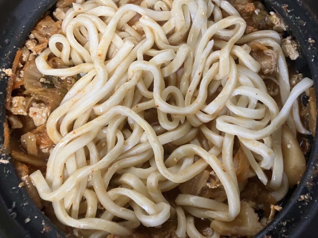 残った鍋にうどんを入れた画像