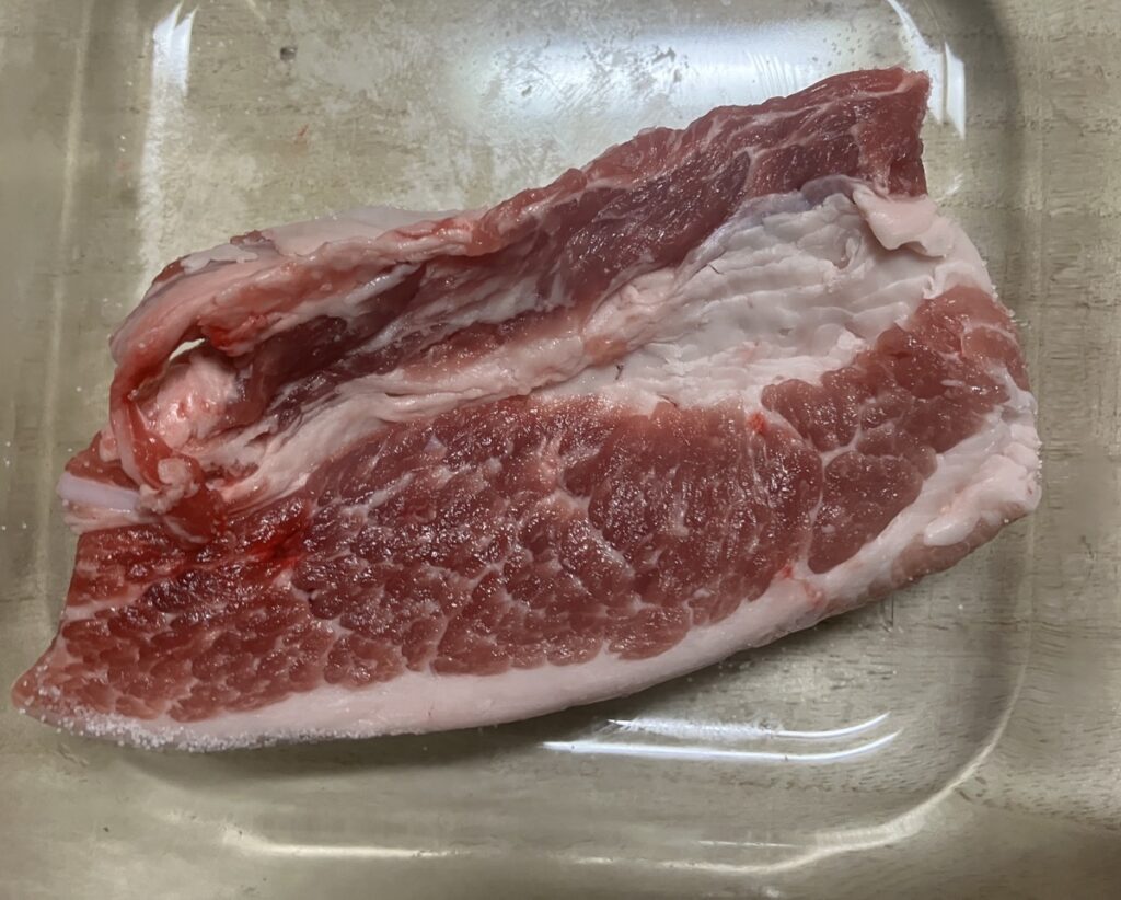 豚肉をフォークで刺し、塩をすり込んだ画像