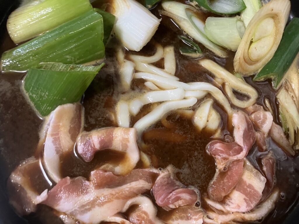 鍋焼きうどんの材料を入れ煮込んでいる画像