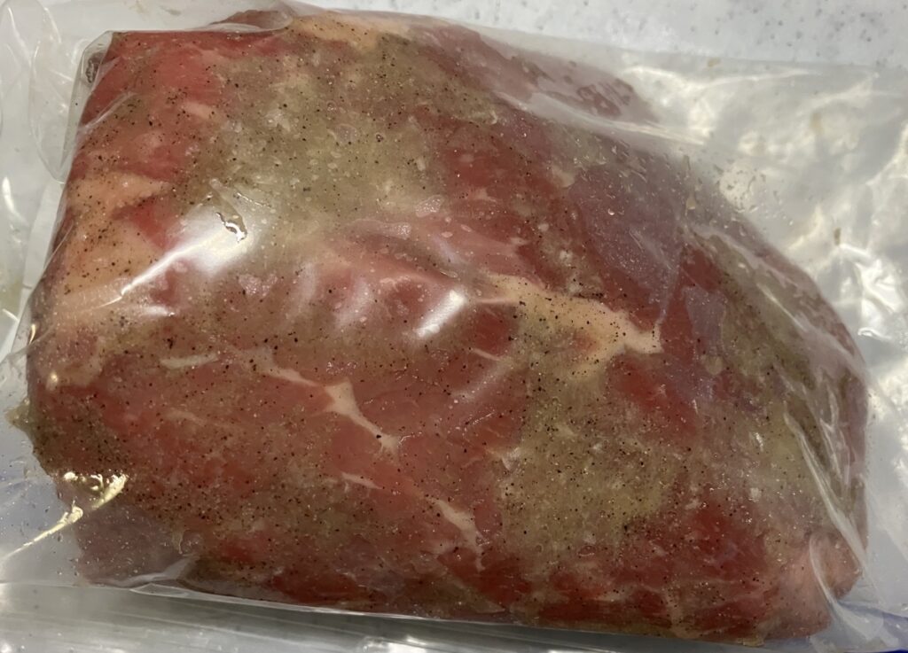 牛もも肉に、塩、胡椒、にんにくをすりこみ密閉袋に入れた画像