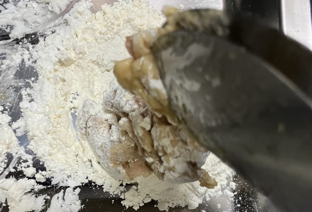 小麦粉(大さじ2)と片栗粉(大さじ２)を混ぜ合わせ、漬け込んだ鶏肉にまぶしている画像