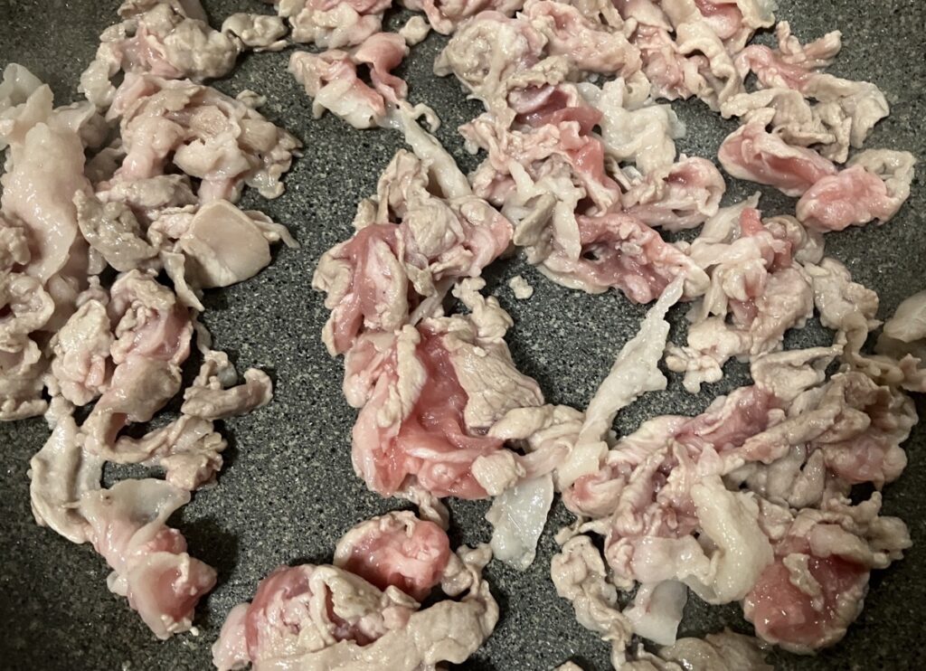 豚肉を炒めている画像